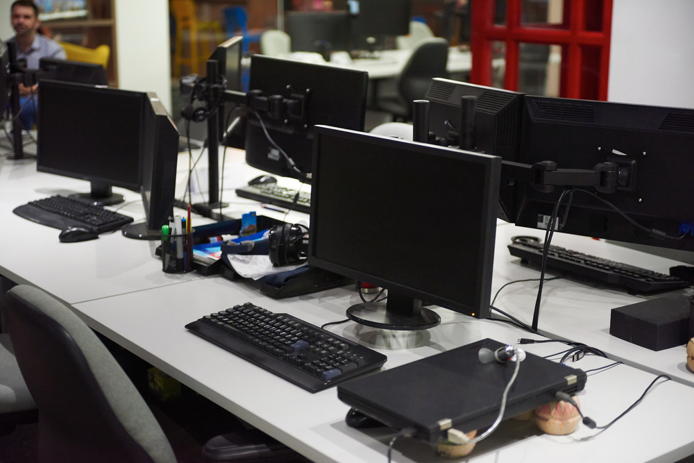 在室内现代办公室中使用双显示器屏幕和膝上型计算机启动公司的软件开发技术